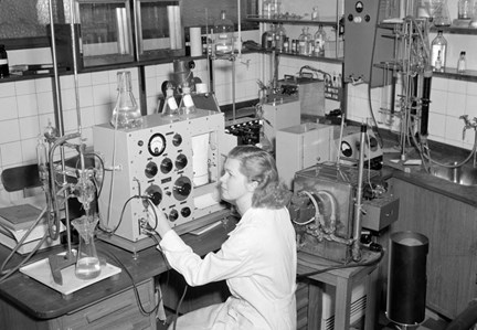En kvinna sitter vid en maskin i ett laboratorium där mjölkprodukter testas. 