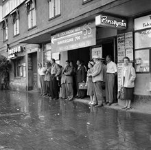 Tegelbacken. Stockholmare söker skydd för regn utanför vänthall