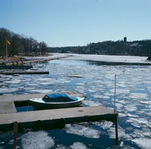 Islossning vid Kungliga Motorbåtklubbens hamn i Djurgårdsbrunnsviken. Brygga med bensinpumpar. Vy österut från Djurgårdsbron