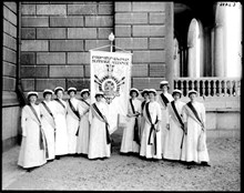 Deltagare i rösträttskongressen 1911 på Södra Blasieholmshamnen med standar där texten lyder "International woman suffrage alliance".
