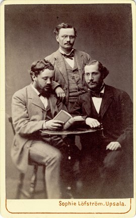 Visitkort med porträttbild av Knut Wicksell tillsammans med Hjalmar Öhrvall till höger och Theodor Frölander till vänster.