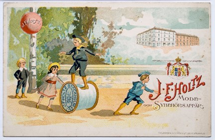 Reklamkort i flerfärgstryck med barn som leker med en stor trådrulle, ballong, ett stort hus samt text.