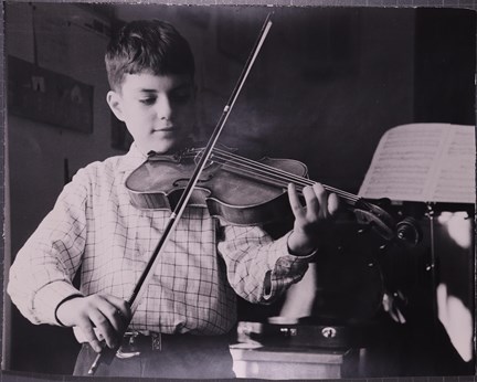 Svartvitt fotografi på pojke som spelar fiol