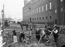 Män med hästar och kärror i arbete framför Stadshuset