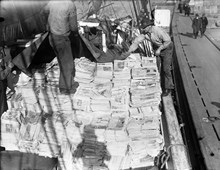 En båt lastas med tidningar som ska till pappersbruk