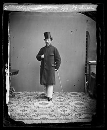 Porträtt av herr Sandell i ytterrock, hög hatt och promenadkäpp