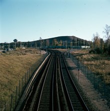 Tunnelbanespåren söderut från Högdalen med Högdalstoppen i fonden