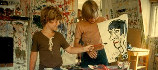 Två barn målar en teckning