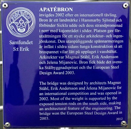 Blå, emaljerad metallskylt med vit text