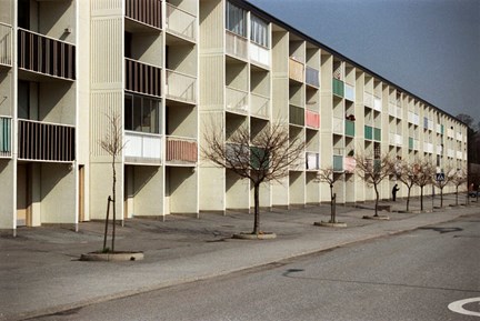 Flerbostadshus med olikfärgade balkongräcken.