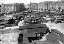 Kvarteret Träskfloden med kåkbebyggelse vid nuvarande Jarlaplan. T.v. Birger Jarlsgatan, t.h. Karlavägen. I fonden Katolsk- Apostoliska kyrkan (nuvarande Grekisk-ortodoxa kyrkan Sankt Georgios)