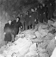 Sprängningar för tunnelbanebygget 20 meter under jord, korsningen S:t Eriksgatan-Kungsholmsgatan. En grupp människor i bergsrummet