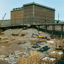 Grundarbeten i de utgrävda kvarteren Frigga och Skansen. Vy åt nordost mot Telegrafverket i kv. Fyrmörsaren. Beridarbansgatan på stolpar