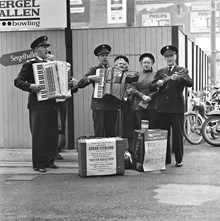 En grupp från Frälsningsarmén sjunger samt spelar dragspel och mandolin på gatan