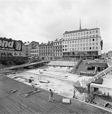 Sergels Torg under byggnad. Sett mot Drottninggatan 37-39 och ingången till T-Centralens tunnelbanestation.