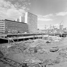 Sergels Torg och Sergelgången under byggnad. Rivna och schaktde norra delen av kv. Skansen. I fonden byggnadsarbete i kv. Hästskon