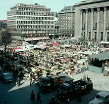 Hötorget mot varuhuset Tempo, Kungsgatan och Konserthuset. PUBs lastbilar i förgrunden