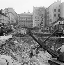 Klarabergsgatan österut/Drottninggatan i fonden med Husmoderns varuhus (Drottninggatan 46). Tunnelbanebygge