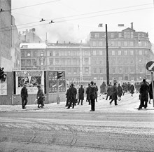 Folk som betraktar släckningsarbete på taket till Arvid Nordquist HAB, Biblioteksgatan 27. Korsningen Sturegatan - Humlegårdsgatan