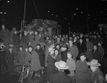 Folksamling kring ett militärfordon.