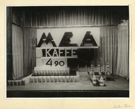 Förpackningar med MEA-kaffe ringlar över golvet i skylfönstret hos varuhuset MEA. 