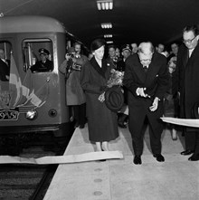 Tunnelbanestation Centralen. Kung Gustaf VI Adolf inviger sammanbindningen av tunnelbanan Slussen-Hötorget genom att klippa bandet framför invigningståget. Till vänster drottning  Louise och till höger borgarrådet Helge Berglund.