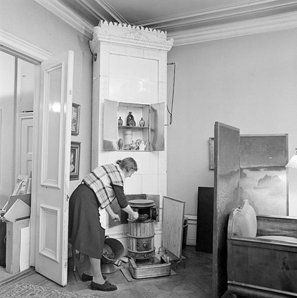 Blasieholmstorg 12. Annastina Alkmans hem. Hembiträdet häller kol i kaminen.