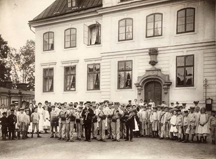 Svartvitt fotografi på barn uppställda med musikinstrument från Frimurarbarnhuset