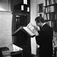 Interiör från Libris antikvariat på Kommendörsgatan 14. Man som studerar gammal bibel