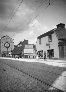 Roslagsgatan strax före korsningen med Surbrunnsgatan. I det mittersta huset låg tidigare värdshuset Clas på Hörnet