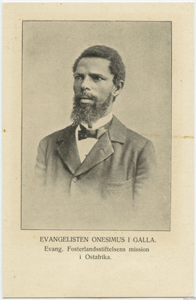 En allvarlig svart man med gråsprängt skägg, kostym och fluga.