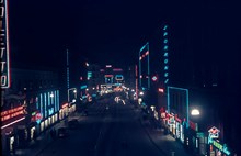 Kungsgatan österut mot Stureplan i mörker med neonskyltar. Tv. ligger Kungsgatan 18 och 14. T.h. 19 och 17