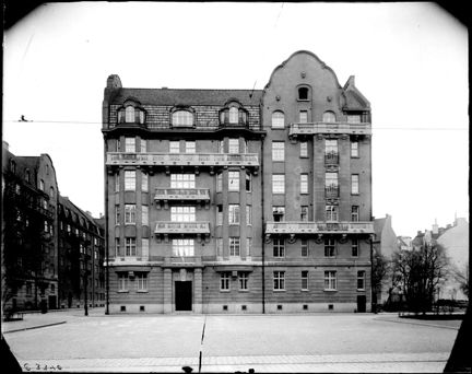 ett stort bostadshus i sten/tegel med många balkonger.