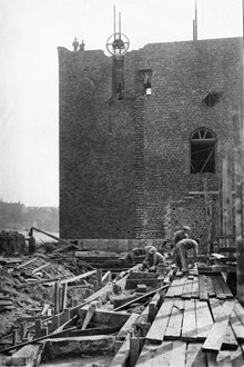 Stadshustornet under uppbyggnad, östra fasaden. Murare och timmermän i arbete.