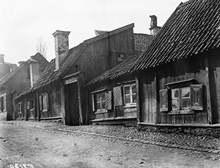 Lilla Badstugatan 13 och 11. En sotare står på en skorsten på taket