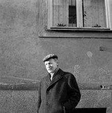 Författaren Per Anders Fogelström framför putsad husfasad