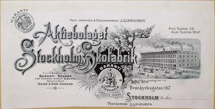 Brevhuvud tryckt i svart med bild på fabrik, dekorationer samt text.