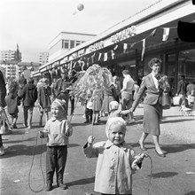 Hässelby Gårds centrum invigs. Barn med pappersvippor i folkvimlet
