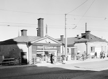 Kv. Järngraven Övra. Julius Sjögren AB järnaffär vid Södermalmstorg 26. T.h. Västra Slussgatan 10. Kvarteret som låg mellan Sjöbergsplan och Södermalmstorg revs 1954