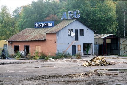 Förfallet hus med skyltar på taket där det står Husqvarna och AEG.