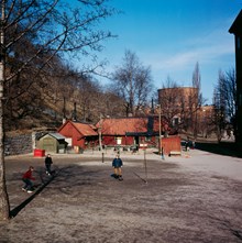 Tre grabbbar sparkar boll vid parkleken i Observatorielunden. I fonden Stadsbiblioteket
