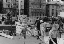 Emil R Boman AB. Liv och rörelse på Skeppsbron, juli 1946. Emil R Bomans, auktoriserade skeppsklarerare, fastighet Skeppsbron 44 längst till vänster.
