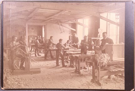 Svartvitt fotografi på pojkar vid slöjdlektion på uppfostringsanstalten Åkerbrukskolonin Hall