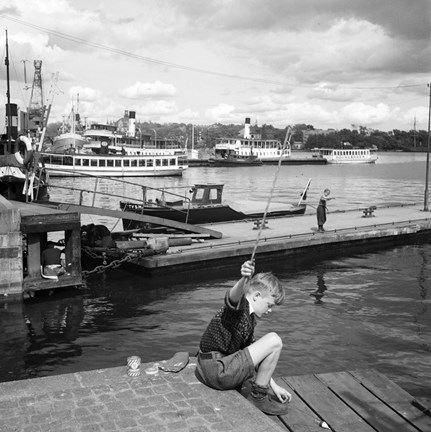 I förgrunden pojke med fiskespö.