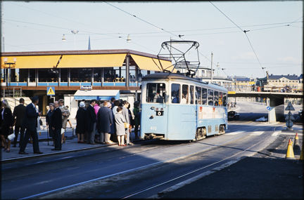 Folk står och väntar på att få kliva på spårvagnen vid Slussen våren 1967