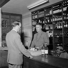 En man köper Kron Brännvin och Absolut Rent i Systembolagets butik