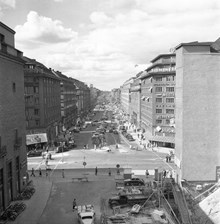 Korsningen Sveavägen och Kungsgatan. Vy Sveavägen norrut. T.h. rivning i kvarteret Järnplåten vid Oxtorgsgatan, förmodligen pga. tunnelbanebygget