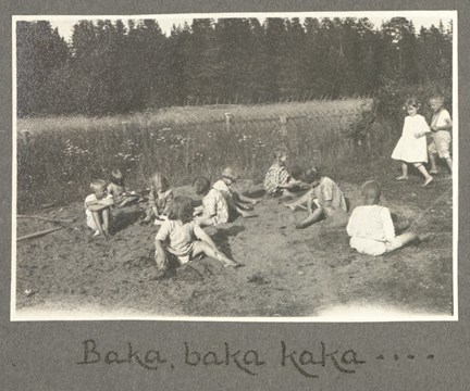 Barn sitter i sanden och leker.