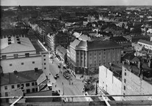 Hörnet Sveavägen och Kungsgatan. Vy från södra Kungstornet, längs Kungsgatan västerut. Spårvagnen svänger in till höger på Sveavägen. Till vänster Konserthuset.