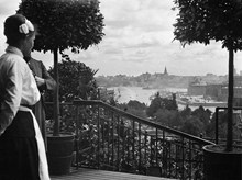 Vy från Nk:s terrass ut över Kungsträdgården, Strömmen och Södermalm. En servitris står till vänster.